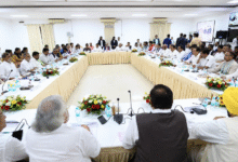 Formal political meeting with leaders seated around a large U-shaped table in a conference hall during INDIA Bloc discussions in Delhi.