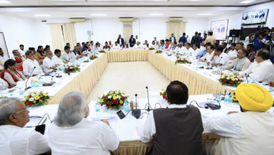 Formal political meeting with leaders seated around a large U-shaped table in a conference hall during INDIA Bloc discussions in Delhi.