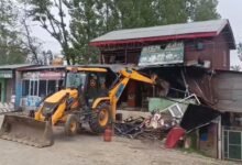 Excavator during Srinagar drug demolition drive illegal shops aur buildings ko demolish karta hua in Kashmir as police anti-encroachment action