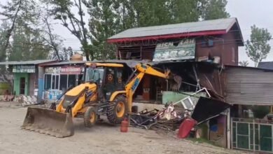 Excavator during Srinagar drug demolition drive illegal shops aur buildings ko demolish karta hua in Kashmir as police anti-encroachment action
