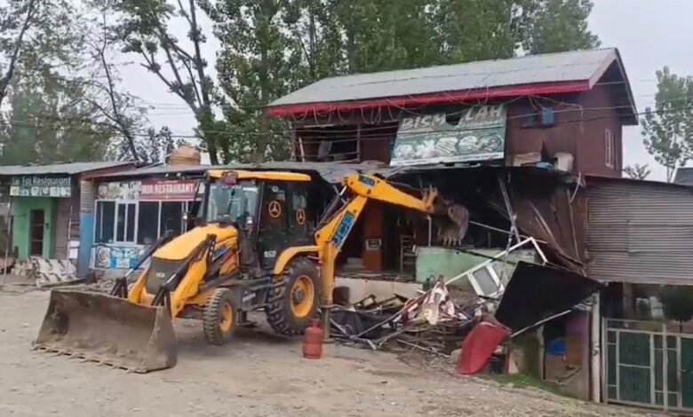 Excavator during Srinagar drug demolition drive illegal shops aur buildings ko demolish karta hua in Kashmir as police anti-encroachment action